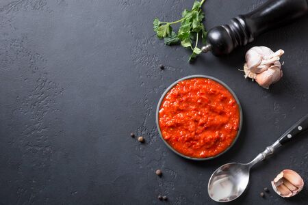 Tasty ajvar on toast. Vegetable sauce or caviar of baked red bell pepper on black. Balkan cuisine. Space for text. Top view.の写真素材