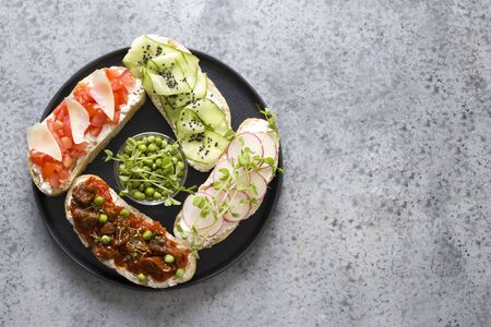 Sandwiches on ciabatta toast with fresh vegetables, radishes, tomatoes, cucumbers, decorated peas...