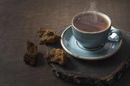 Organic Chaga mushrooms hot coffee in glass cup. Trendy healthy clean eating beverage on dark.の写真素材