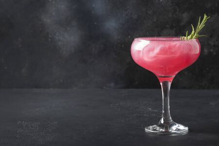 Shimmer edible glitter sparkling rose wine garnish rosemary on grey .の写真素材