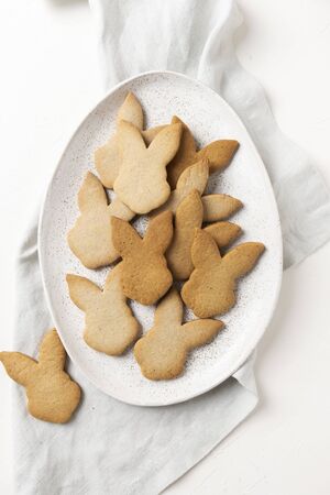 Homemade Easter bunnies shaped cookies on white concrete background. Top view.