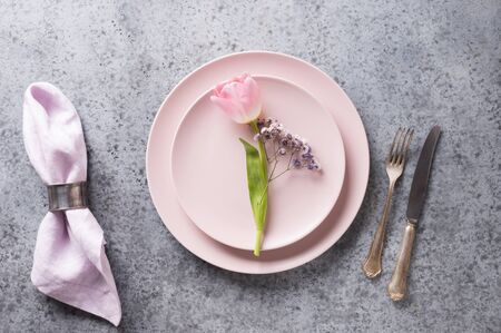 Holiday Easter table setting with pink tulip on grey table. View from above.の写真素材