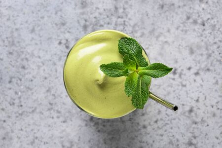 Glass of Dalgona Iced Matcha tea garnish mint on grey. Close up. View from above.の写真素材