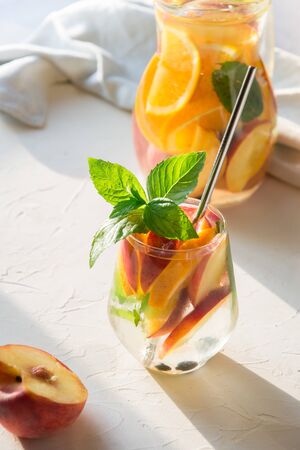 Freshness peach lemonade in glass garnish mint on light background. Summer healthy drink. Vertical.の写真素材