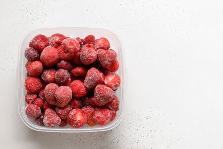 Frozen strawberries in container on white background. View from above.の写真素材