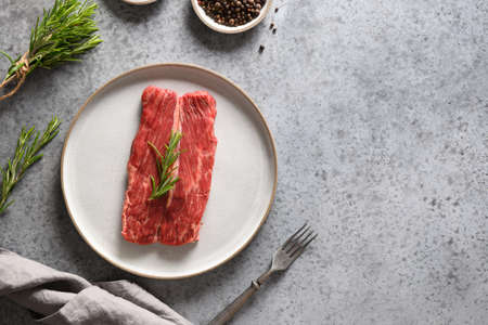Raw marbled ribeye steak with rosemary on grey. Top view. Space for text.の写真素材