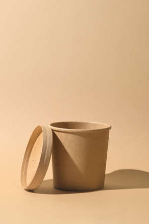Craft paper soup cup with shadow on brown paper background. Empty container. Ecological individual package. Zero Waste.の写真素材