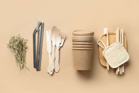 Renewable individual objects for home use, bamboo or metal straws, disposable cups and wooden spoons, forks, toothbrush on beige. Zero waste. Pollution environment. Top view.の写真素材