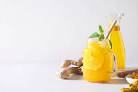 Indonesian freshness Jamu beverage with turmeric, lemon and ginger in mason jar on white background. Space for text.の写真素材
