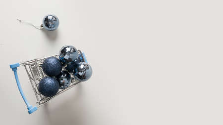 Grocery trolley full of New Years blue balls. Minimal Christmas holiday shopping concept. Space for text. Banner.の写真素材