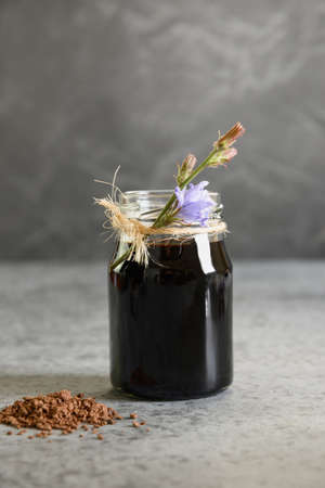 Chicory concentrate in glass and flowers. Healthy herbal beverage, coffee substitute. Close up.の写真素材