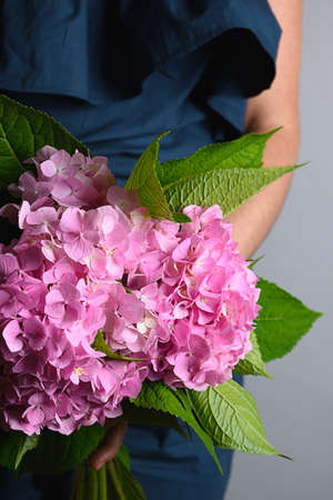 Bouquet of fresh pink hydrangea flower woman hands. Flowers delivery. Vertical format. Floral shop...