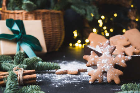 Holiday composition of tasty homemade cookies, gift hamper, gift and garland on black. Christmas vibes. Happy New Year.の写真素材