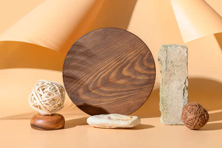 Podiums for products of natural materials stone, bricks, wooden board with sunny shadow on beige background. Monochrome creative template or mock up.の写真素材