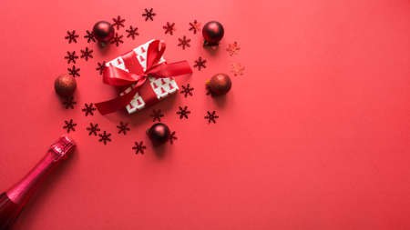 Christmas banner with sparkling wine, gift, red holiday decor on red background. Xmas greeting card....