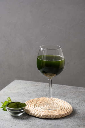 Chlorella healthy Detox beverage with lemon in glass on a gray background. Close up.の写真素材