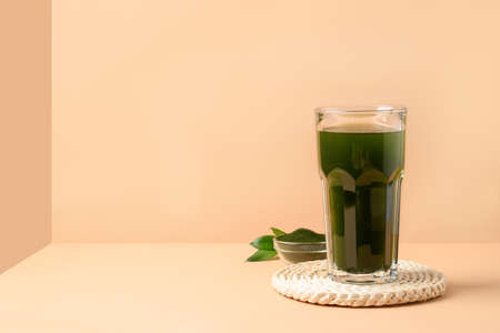 Chlorella Detox drink in glass on modern beige background as cube. Close up.の写真素材
