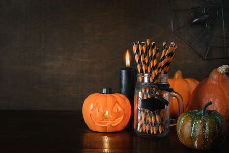 Halloween pumpkin head jack-o-lantern on dark wooden background. Preparation for fun party. Happy Halloween.の写真素材