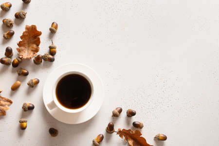 Acorn coffee with oak leaves on white table. View from above. Space for text.の写真素材