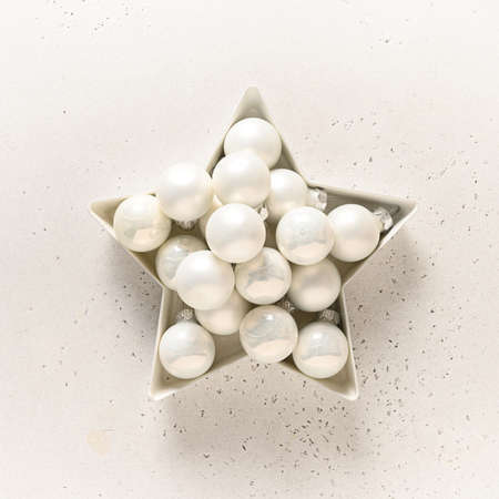 Christmas star with white balls on white. Creative greeting card. Top view. Alternative Creative Xmas tree.の写真素材