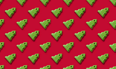 Seamless pattern of gingerbread in shape decorative Christmas tree on red background. Xmas holiday abstract background.の写真素材