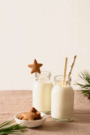 Homemade cookies in shape of star and milk for Santa Claus and christmas tree on table. Close up.の写真素材