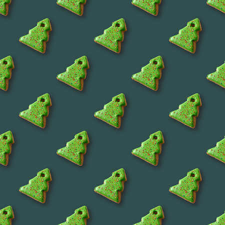 Seamless pattern of gingerbread in shape decorative Christmas tree on green background. Xmas holiday abstract background.の写真素材