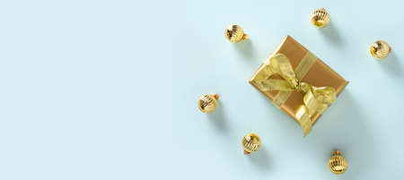 Christmas golden gift and balls on blue as banner. Top view. Xmas modern banner for holiday greeting card.の写真素材