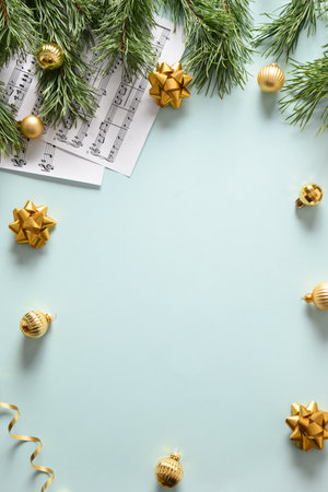 Music sheets for Christmas Carols and sings decorated golden balls on blue background. View from above. Vertical format.の写真素材
