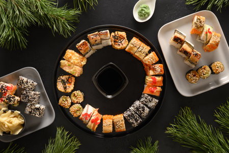 Holiday Christmas brunch of sushi set as wreath on black background. View from above. Flat lay style. Xmas or New Year festive party.の写真素材