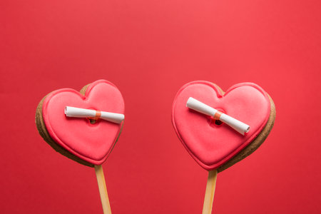 Couple glazed cookies in shape of heart with Love letter on red background. Funny concept. Greeting card copy space. Close up.の写真素材
