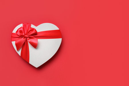 Red white gift in shaped of heart isolated on red background. Top view. Flat lay. Valentines day greeting card with space for text.の写真素材