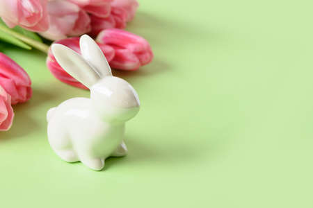 Easter greeting card with bunny and tulips flowers on green background with copy space.の写真素材