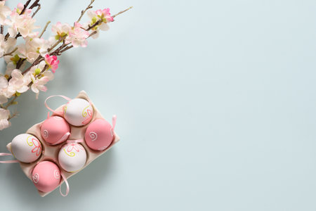 Easter pastel eggs and spring blooming flowers on blue. View from above. Space for text.の写真素材