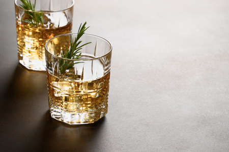 Two shot of whiskey with ice cube on brown background. Close up.の写真素材