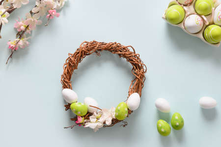 Makind Easter wreath of colorful pastel eggs on blue. View from above. Christianity tradition.の写真素材