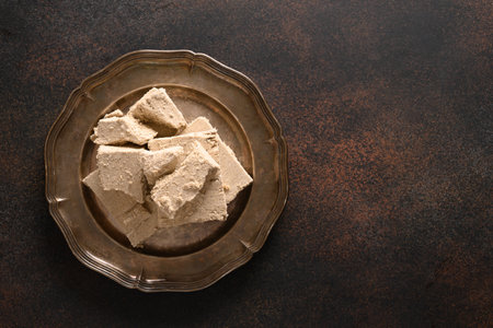 Tasty sweet dessert halva prepared from sunflower seeds on brown background with copy space. View from above.の写真素材