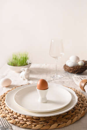 Spring stilish Easter table setting with organic eggs, bunny and blooming flowers.
