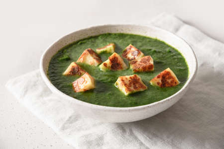 Palak Paneer served basmati rice on white.