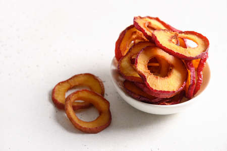 Dried sliced plums in bowl on white. Fall harvest. Home drying.