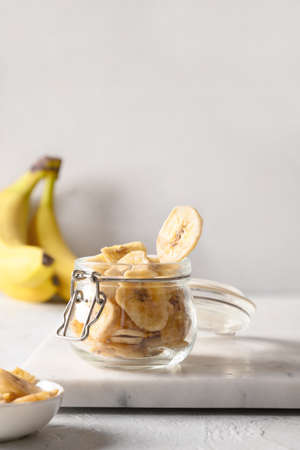Banana chips in glass jar, home drying.の写真素材