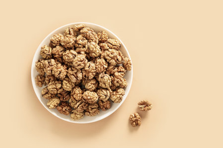 Healthy walnuts without shells in white plate on beige.の写真素材