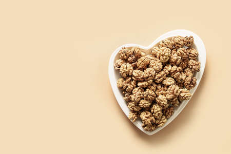 Fresh walnuts without shells in shape of heart. Walnuts concept as healthy food for heart.
