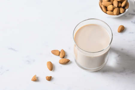 Fresh almond milk and nuts on white background.の写真素材
