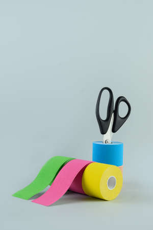 Rolls kinesiology tape and scissors on blue background.の写真素材