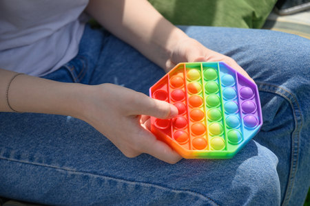 Girl play in silicone anti stress Pop It in hexagon shape toy.
