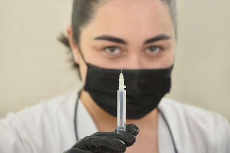 Doctor holds and prepares a syringe for beauty injection. Caucasian woman