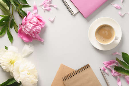 Creative female mockup with coffee cup, peony flowers, sketchbook for planning.