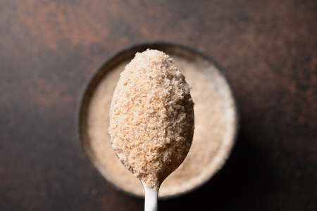 Psyllium husk in spoon on brown background.の写真素材