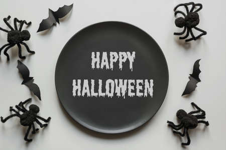 Halloween invitation to fun Horror Party. Black spiders, bat and black plate with text Happy...